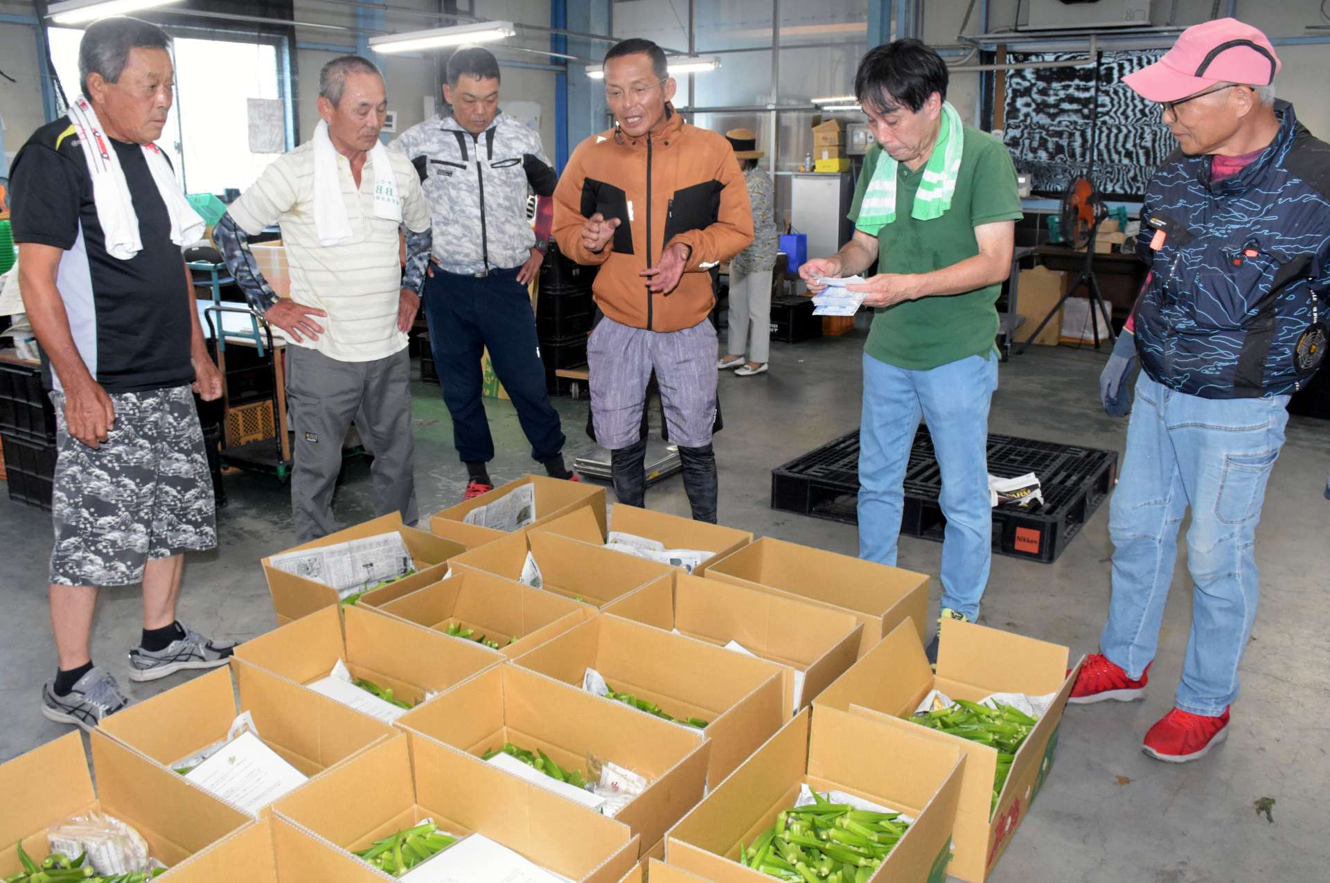 福島の園児に贈るオクラの箱詰め作業をする有志ら＝指宿市のＪＡいぶすき東部配送センター
