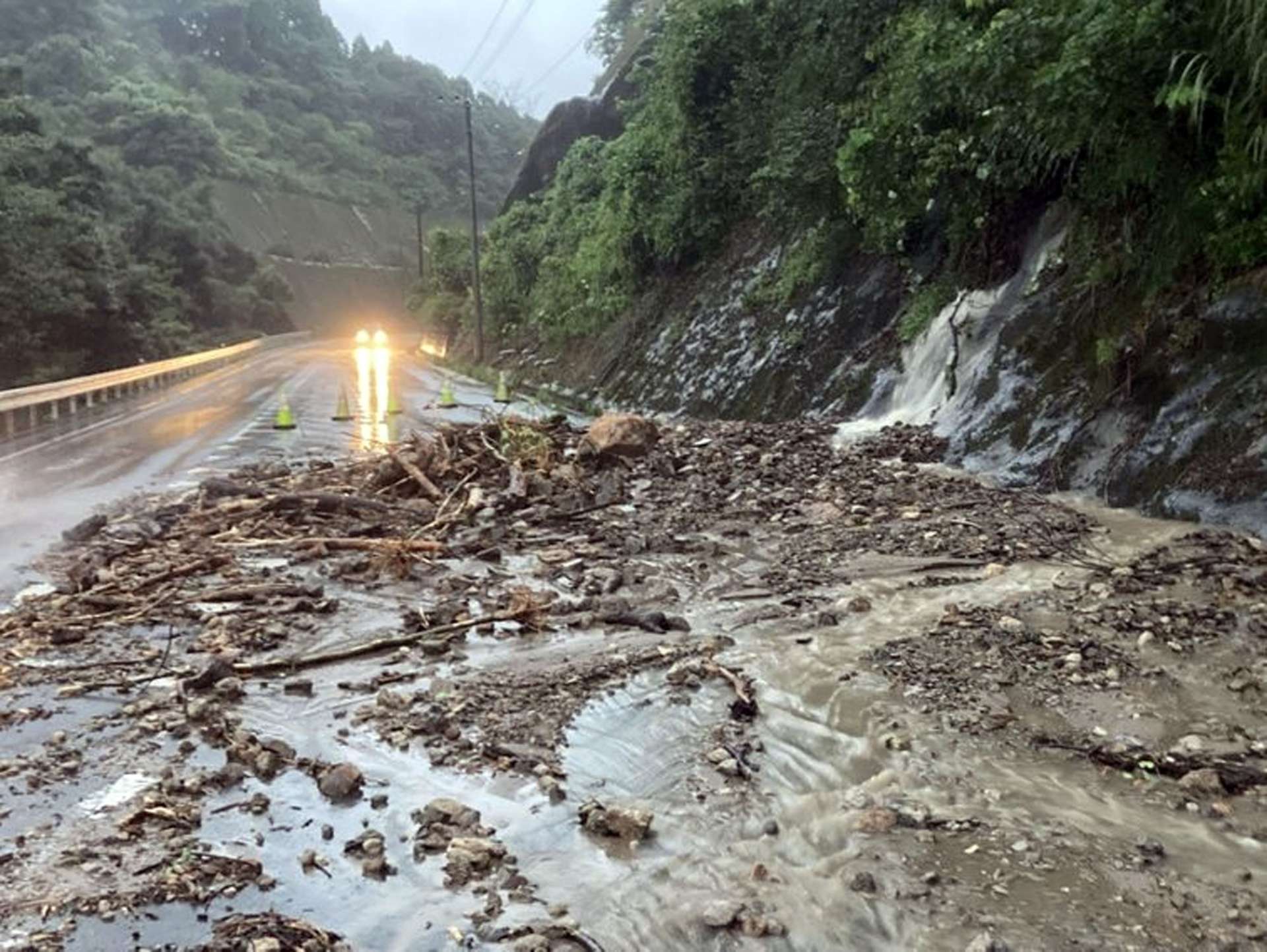 〈関連〉土砂が道路に流入した県道鹿児島川辺線＝２２日、南九州市川辺町神殿（南薩地域振興局土木建築課提供）