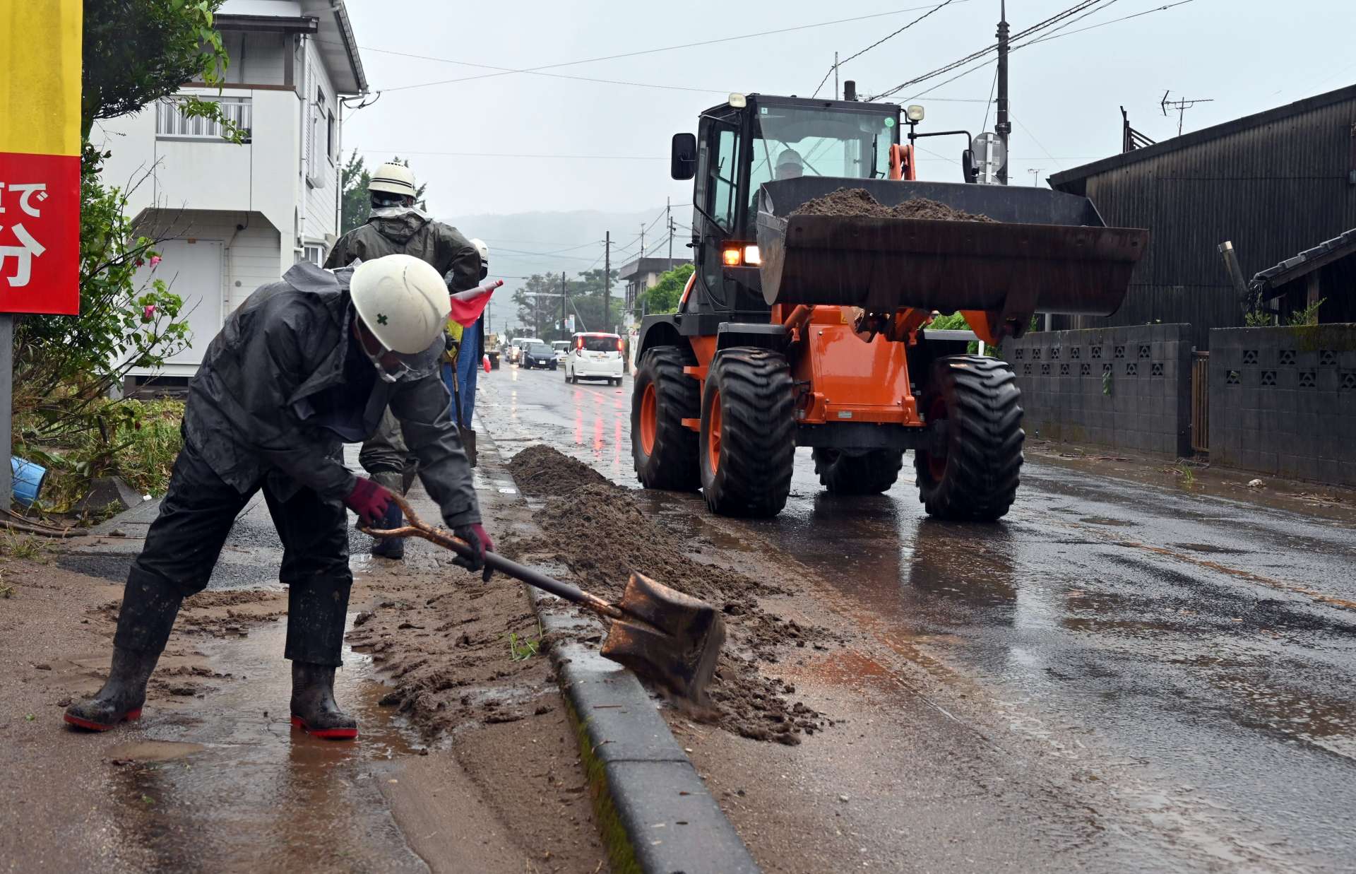道路に流入した土砂を除去する作業員ら＝２２日午前９時２２分、南さつま市加世田内山田