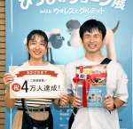来場４万人目の島倉拓朗さん（右）＝２２日、鹿児島市の黎明館