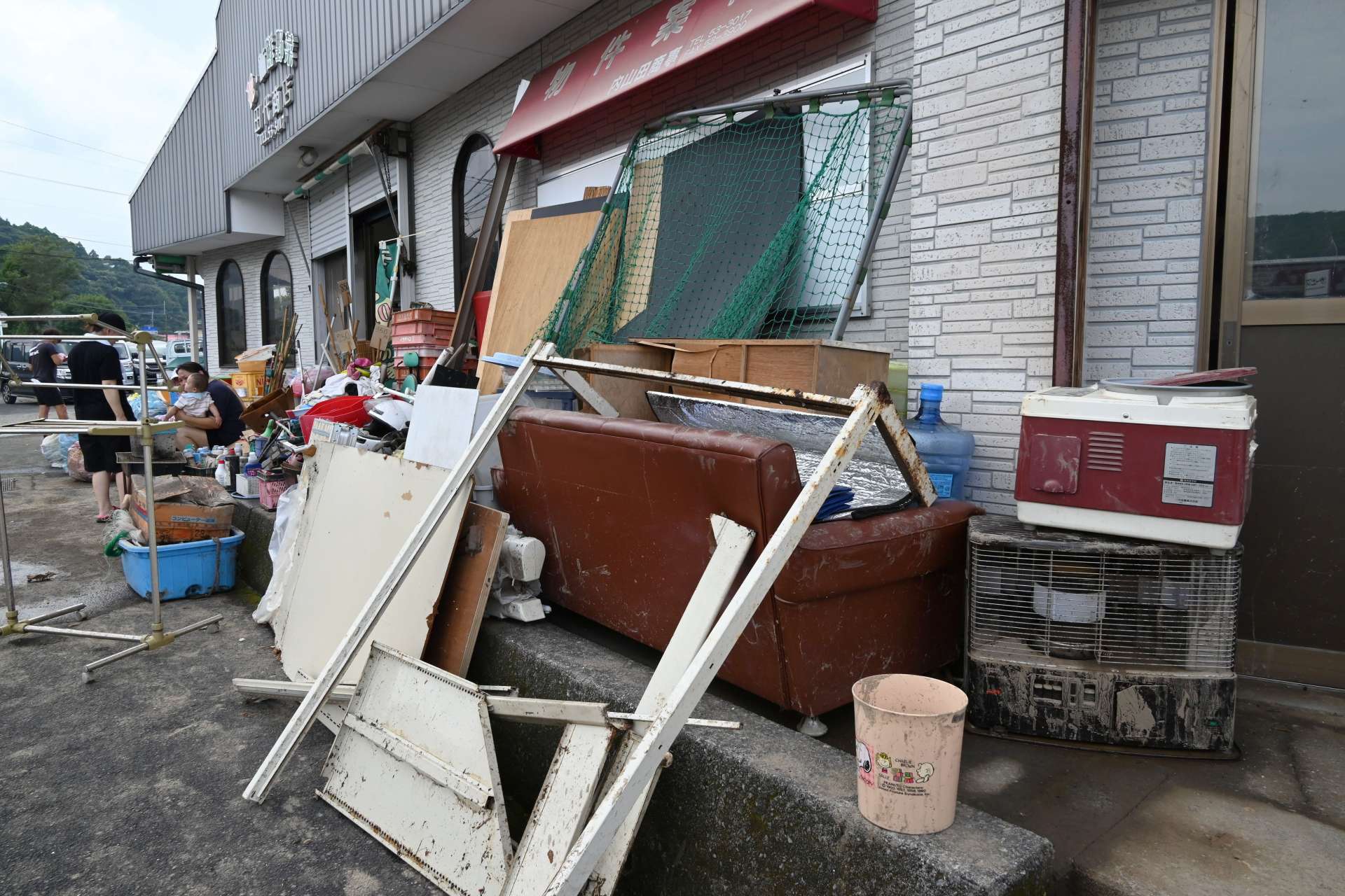 冠水し、外に出された家具やストーブ＝２２日午後２時半ごろ、南さつま市加世田内山田