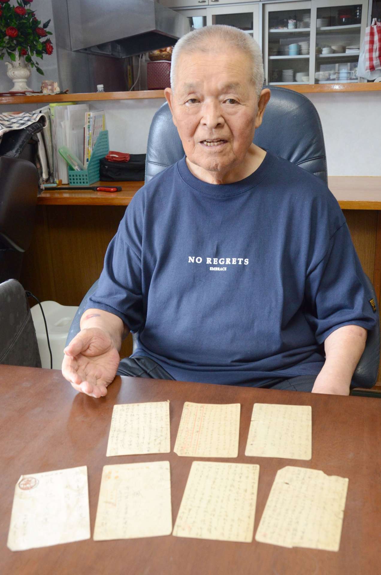 父静雄さんが家族に送ったはがきを前に、思いを語る渡辺忠さん