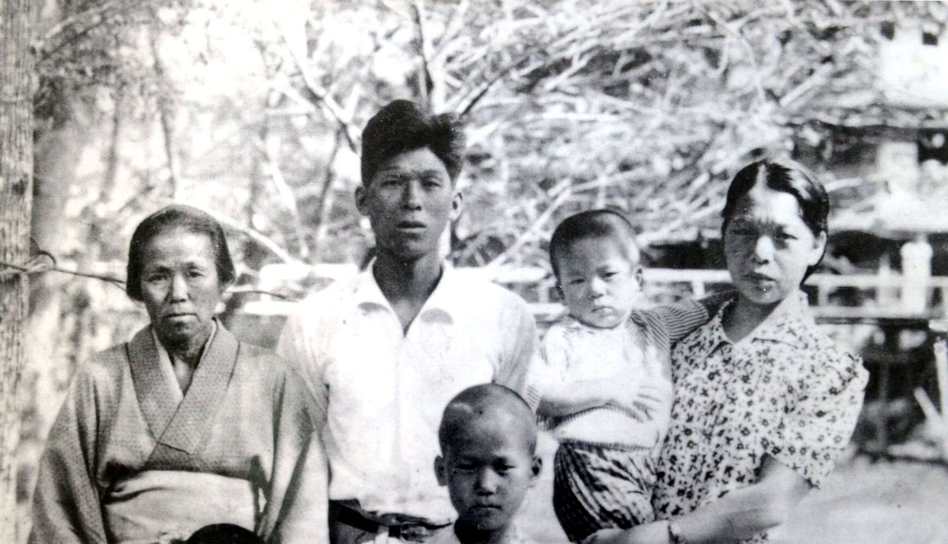 １９４０年ごろ撮影された家族写真。母に抱かれる渡辺忠さん、前列は兄誠利さん（渡辺さん提供）