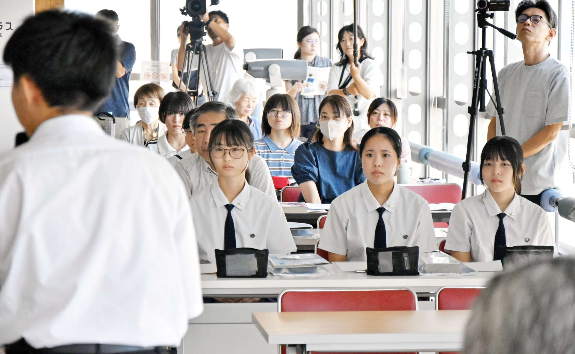 福留豪希さんの解説を聞く高校生ら＝２３日、鹿児島県庁