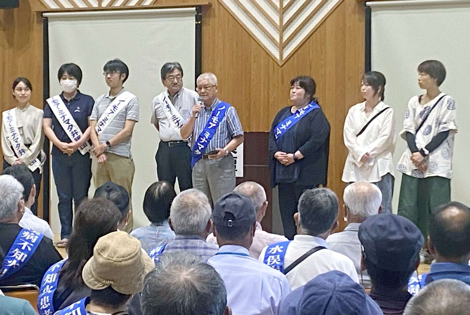 「公式確認から６９年たっても解決しない」と国や原因企業を批判する山下重儀さん（中央）＝２４日、熊本県水俣市のもやい館