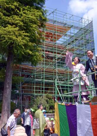 〈関連〉三重塔の上棟を祝い餅まきをする攝護寺の佐々木慈舟住職（右から２人目）ら＝都城市牟田町