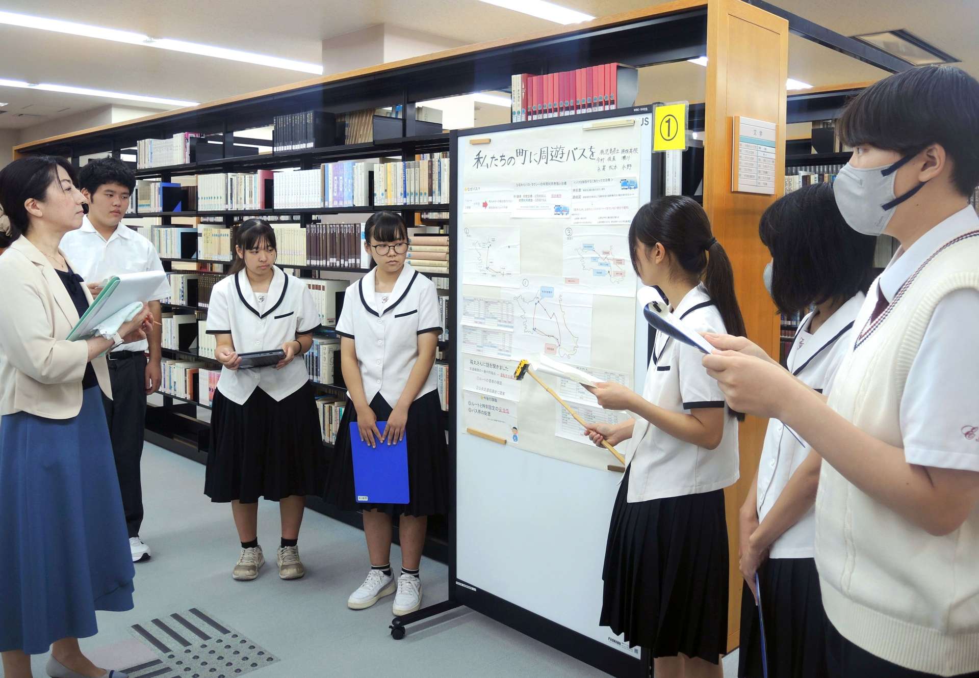 工夫を凝らしたポスターを使い研究成果を説明する生徒＝鹿児島市の鹿児島国際大
