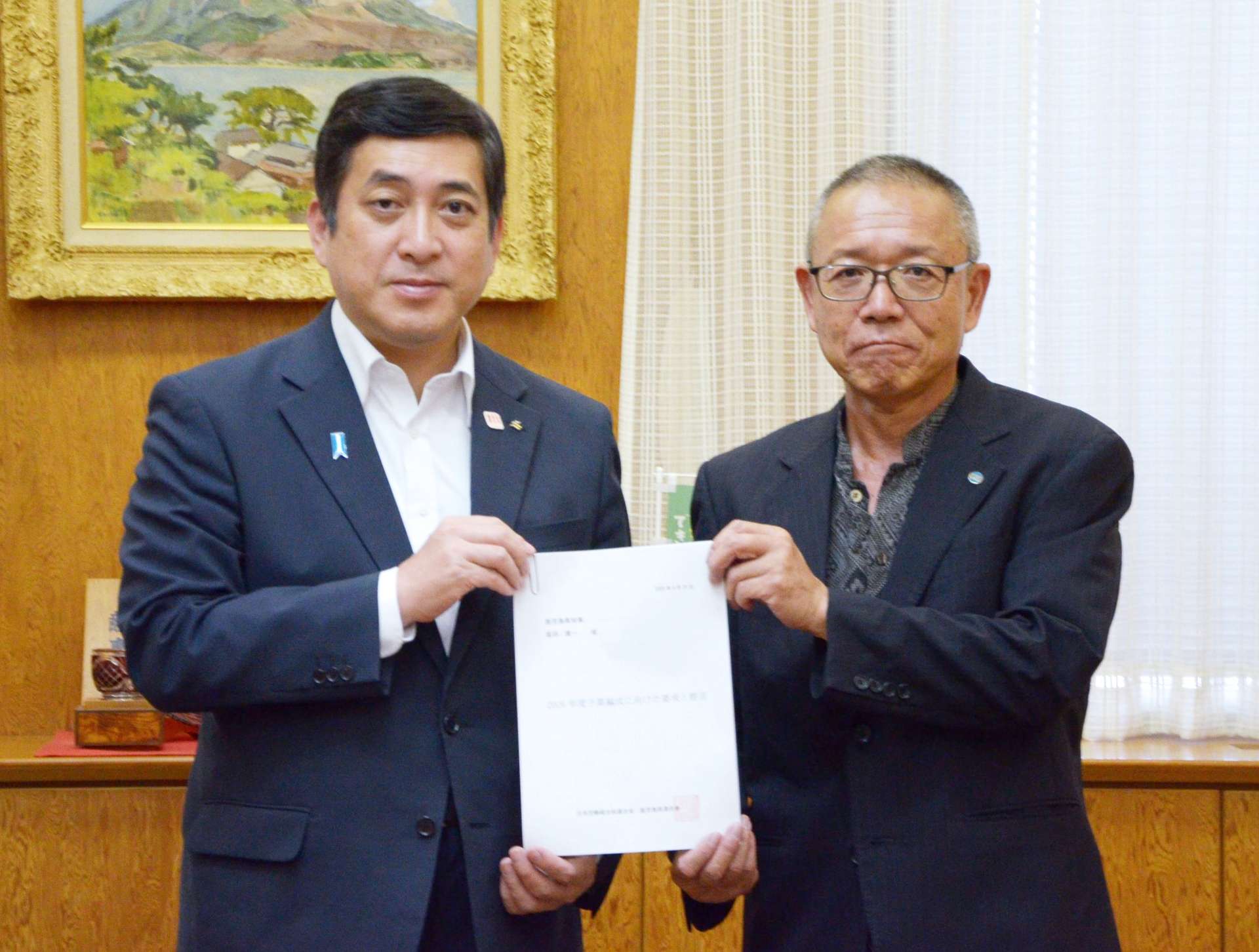 来年度の予算編成に向けた要求・提言書を手渡した連合鹿児島の下町和三会長（右）＝２５日、県庁