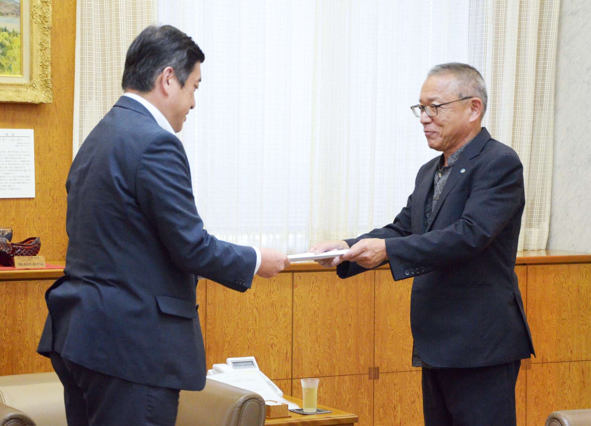 来年度の予算編成に向けた要求・提言書を手渡す連合鹿児島の下町和三会長（右）＝２５日、県庁