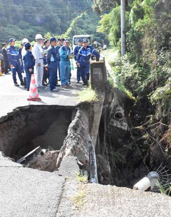 水道管が損傷した現場を視察する坂井学防災担当相＝２５日、霧島市隼人町西光寺