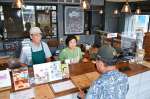 閉店を知って訪れた客と話す森田康之さん（左）と恵子さん＝２３日、姶良市加治木