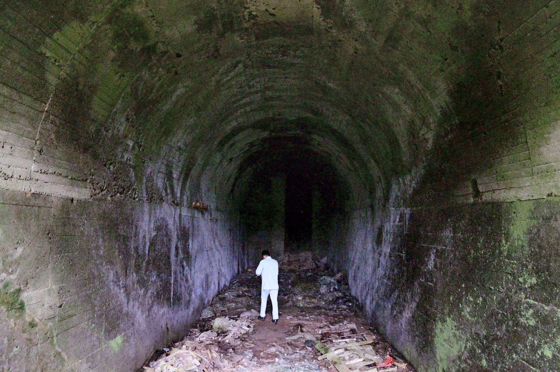 シラスの崖に残るコンクリート造りの壕は、旧日本軍の発電所跡と伝わる＝２１日、志布志市安楽平床