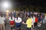 住民と一緒に八月踊りを踊る尼崎市の中学生ら＝龍郷町