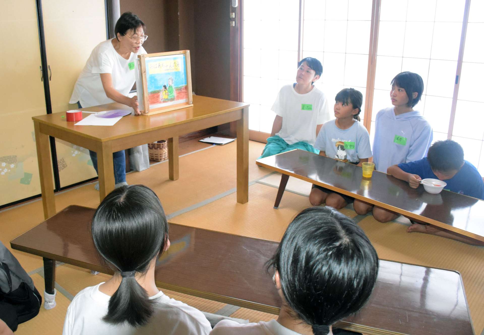 戦争の実体験を元にした紙芝居を鑑賞する参加者＝２６日、指宿市東方