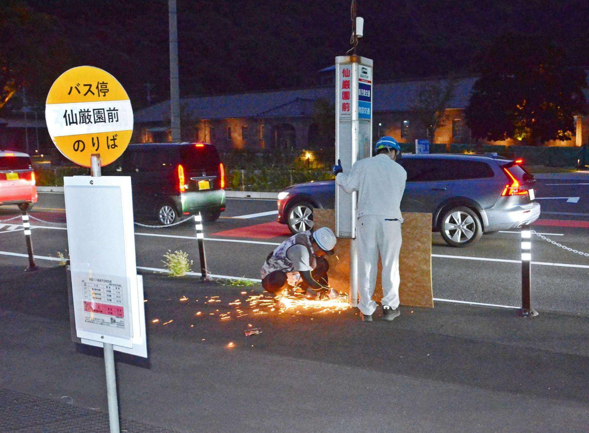 撤去される仙巌園前のバス停標識。手前は新たに設置された標識＝２８日午後７時ごろ、鹿児島市吉野町