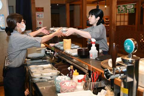 開店前、テーブルを拭くパートの従業員。最低賃金改定は多くの労働者に影響する＝鹿児島市与次郎１丁目の「はいから亭」