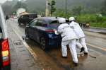 水没した車を移動させる警察官＝２２日、南さつま市加世田内山田
