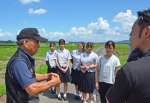 夢ファームたろぼうの竹之下征秀組合長（左）からみやだいず栽培についての説明を受ける都城農業高校の生徒＝都城市太郎坊町