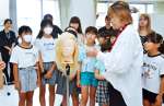 ヘアアレンジのお手本を見せてもらう参加者＝８月２３日、鹿児島市上荒田町の赤塚学園