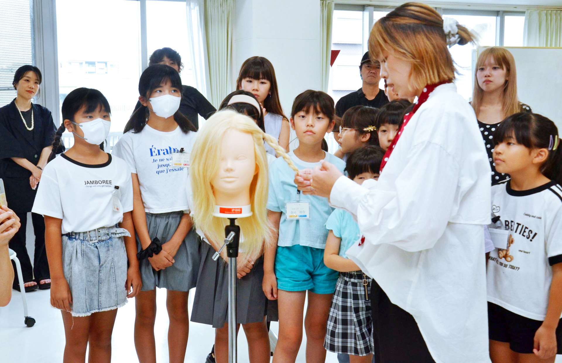 ヘアアレンジのお手本を見せてもらう参加者＝８月２３日、鹿児島市上荒田町の赤塚学園