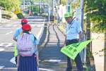 集団登校の児童らに声をかける西耕治校長＝１日、姶良市の竜門小学校