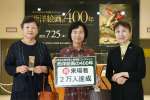来場者２万人目となった室屋明子さん（中央）＝２日、鹿児島市立美術館