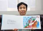 〈関連〉母親の絵本を手にする節政玲子さん＝薩摩川内市