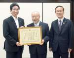 記念撮影をする渡辺組の渡辺紘起会長ら＝鹿児島市役所