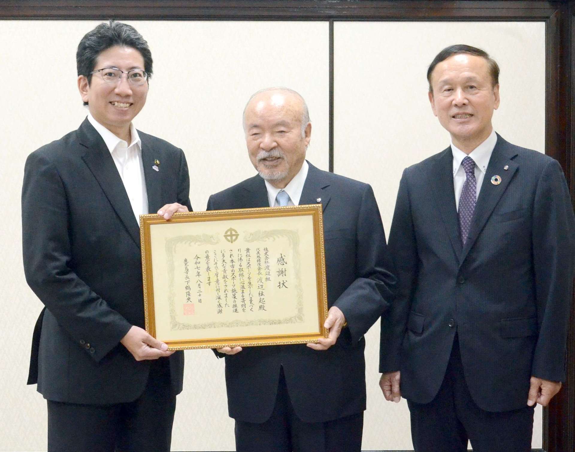 記念撮影をする渡辺組の渡辺紘起会長ら＝鹿児島市役所