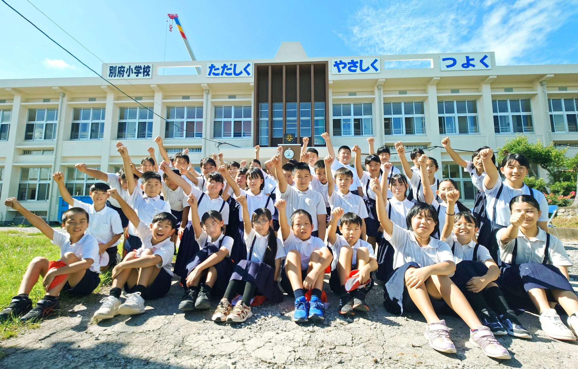 新しくなった校舎を前に、気勢を上げる児童＝１日、南九州市頴娃の別府小学校
