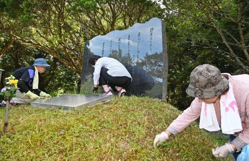 扇山災害慰霊碑の草むしりをする女性たち＝３日、南さつま市金峰町大坂