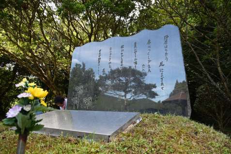 〈関連〉犠牲となった当時１２歳の少年が書いた「野原はうたう」の詩が刻まれた慰霊碑。自然豊かな景色が映り込む