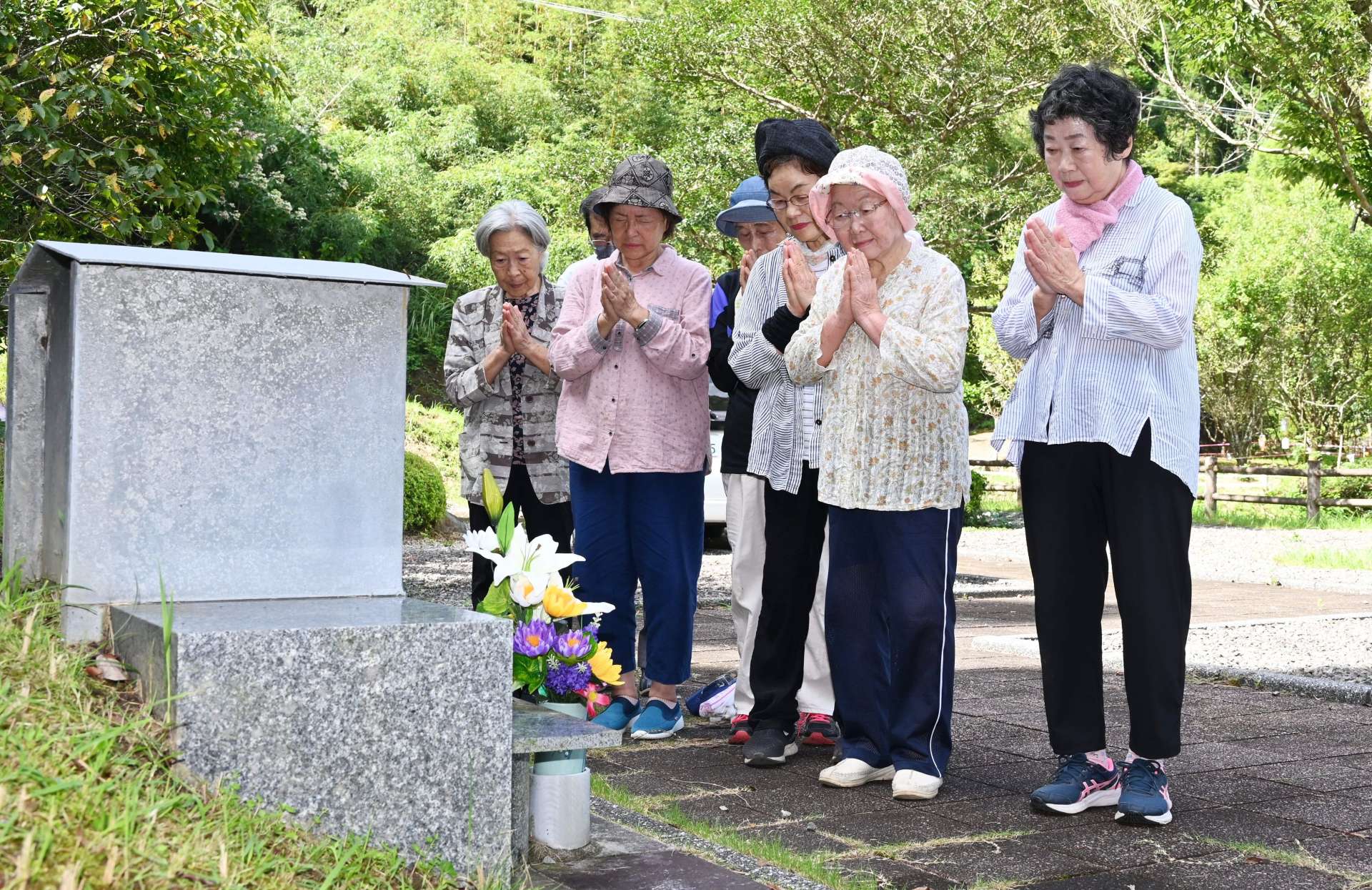 扇山災害の慰霊碑前で手を合わせる人々＝３日、南さつま市金峰町大坂