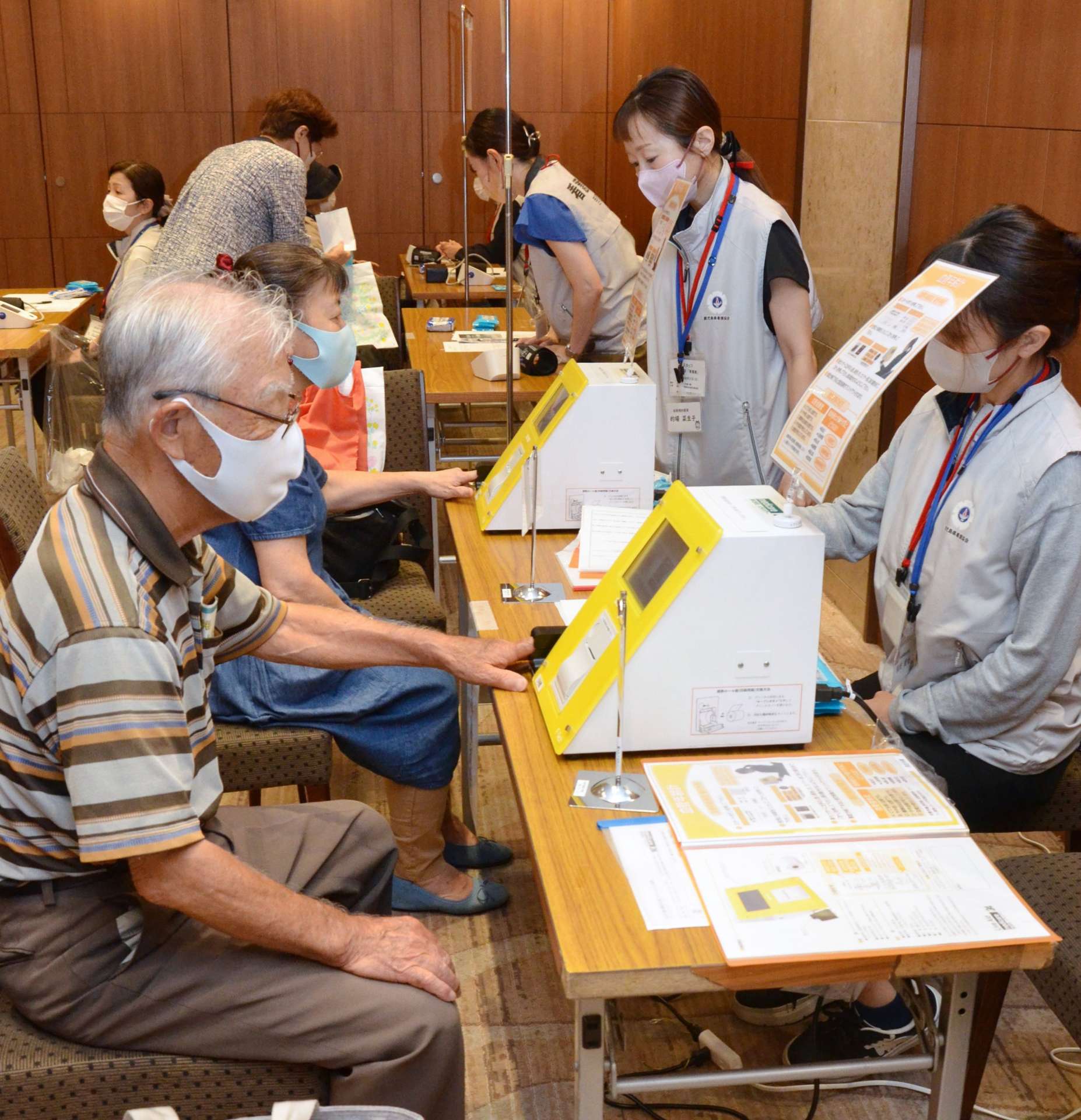 血管年齢を測定する買い物客＝８月３１日、鹿児島市の山形屋
