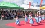 秋のグルメ祭りのキックオフイベントで、フラダンスのステージを楽しむ来場者＝指宿市の指宿港