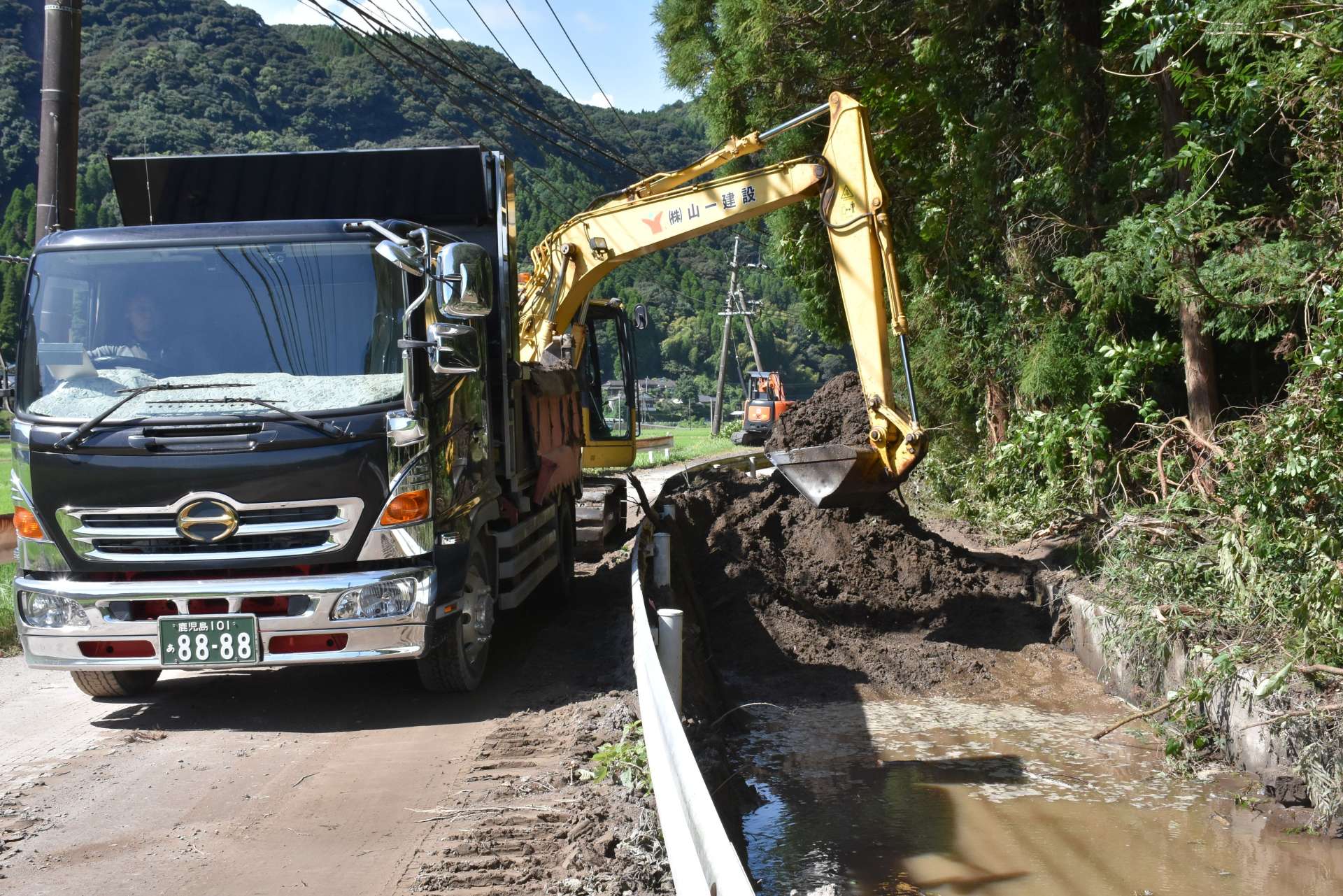 農業用水路に流れ込んだ土砂の撤去作業＝８月１３日、霧島市隼人町松永