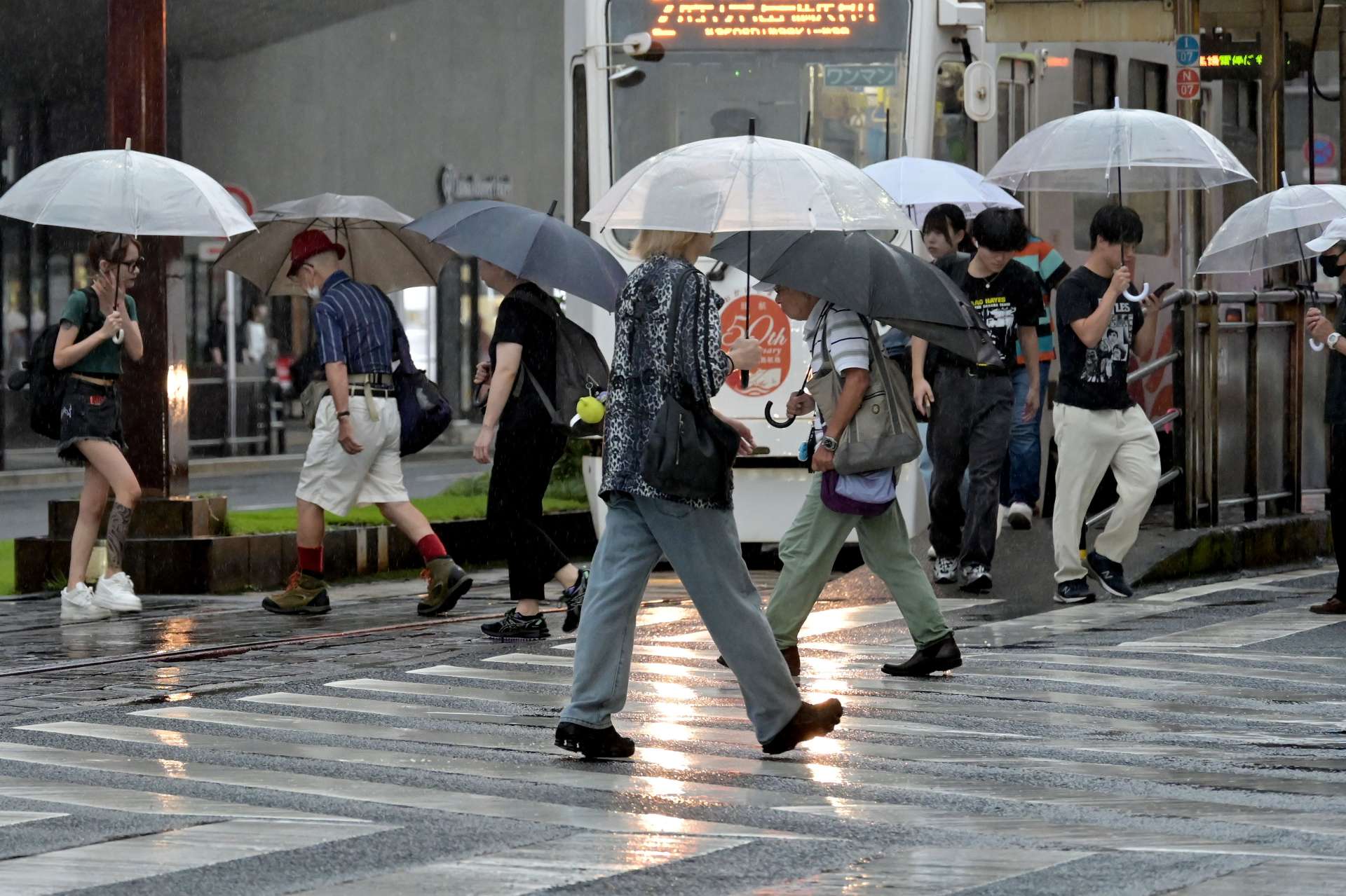 激しい雨の中、傘をさして足早に歩く市民＝１０日午前９時２３分、鹿児島市東千石町