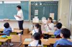 研究資料としてタブレット端末で授業の様子を撮影する教員＝１１日、鹿児島市の鹿児島大学付属小学校