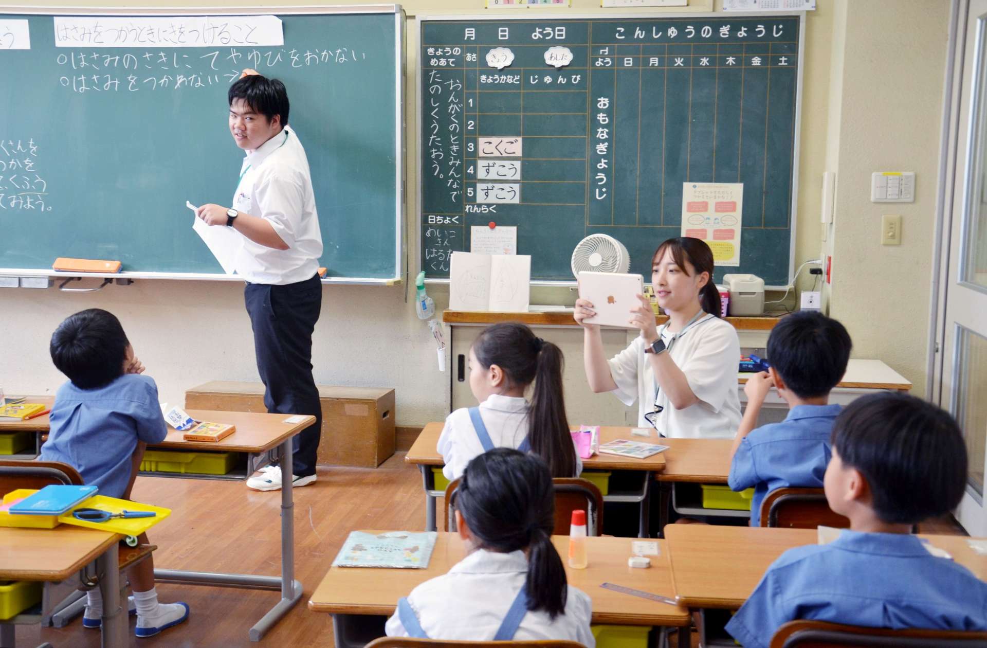 研究資料としてタブレット端末で授業の様子を撮影する教員＝１１日、鹿児島市の鹿児島大学付属小学校