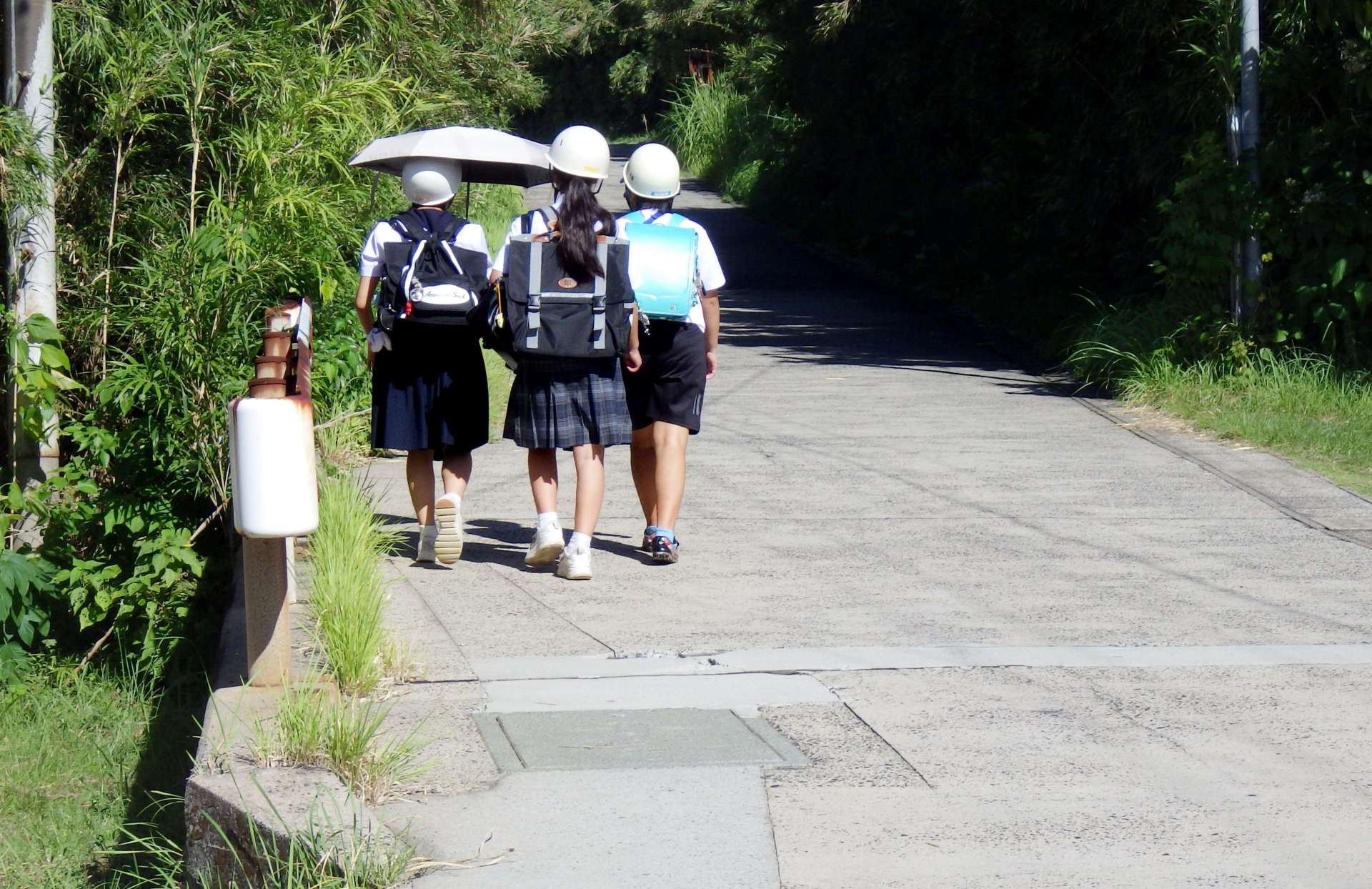 ヘルメットをかぶって下校する諏訪之瀬島学園の児童ら（同学園提供）