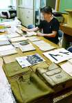 菱田小学校に届いた迫水久常・元内閣書記官長の遺品に目を通す平山淳郎校長＝８月、大崎町の菱田小学校
