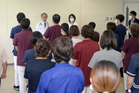 医療法人徳洲会による運営が始まり、朝礼に集まった職員ら＝１日、南種子町の公立種子島病院