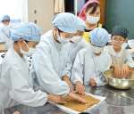 げたんはの生地をのばす子どもたち＝霧島市横川町上ノの安良小学校