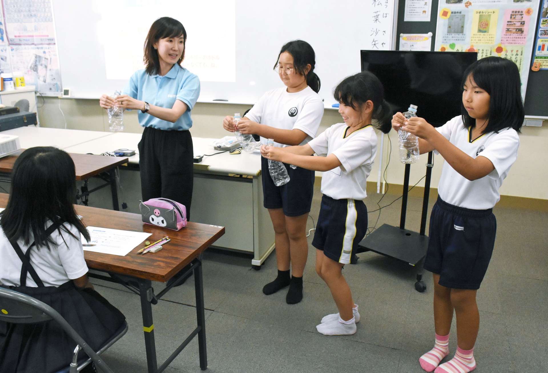 ペットボトルの簡単なつぶし方に挑戦する児童＝出水市の切通小学校
