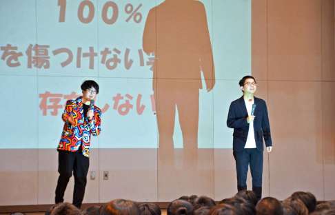 笑いを通じたコミュニケーションについて話すオシエルズの矢島ノブ雄さん（左）と野村真之介さん＝鹿児島市の谷山北中学校