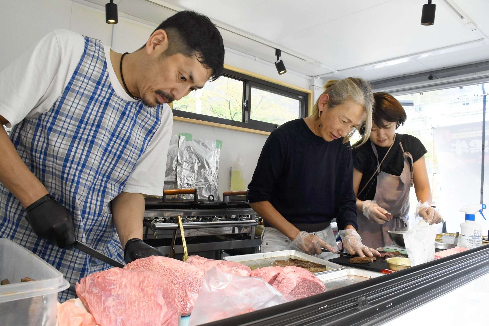 鹿児島黒牛のランプ肉を調理する出店者＝１８日、東京都中央卸売市場