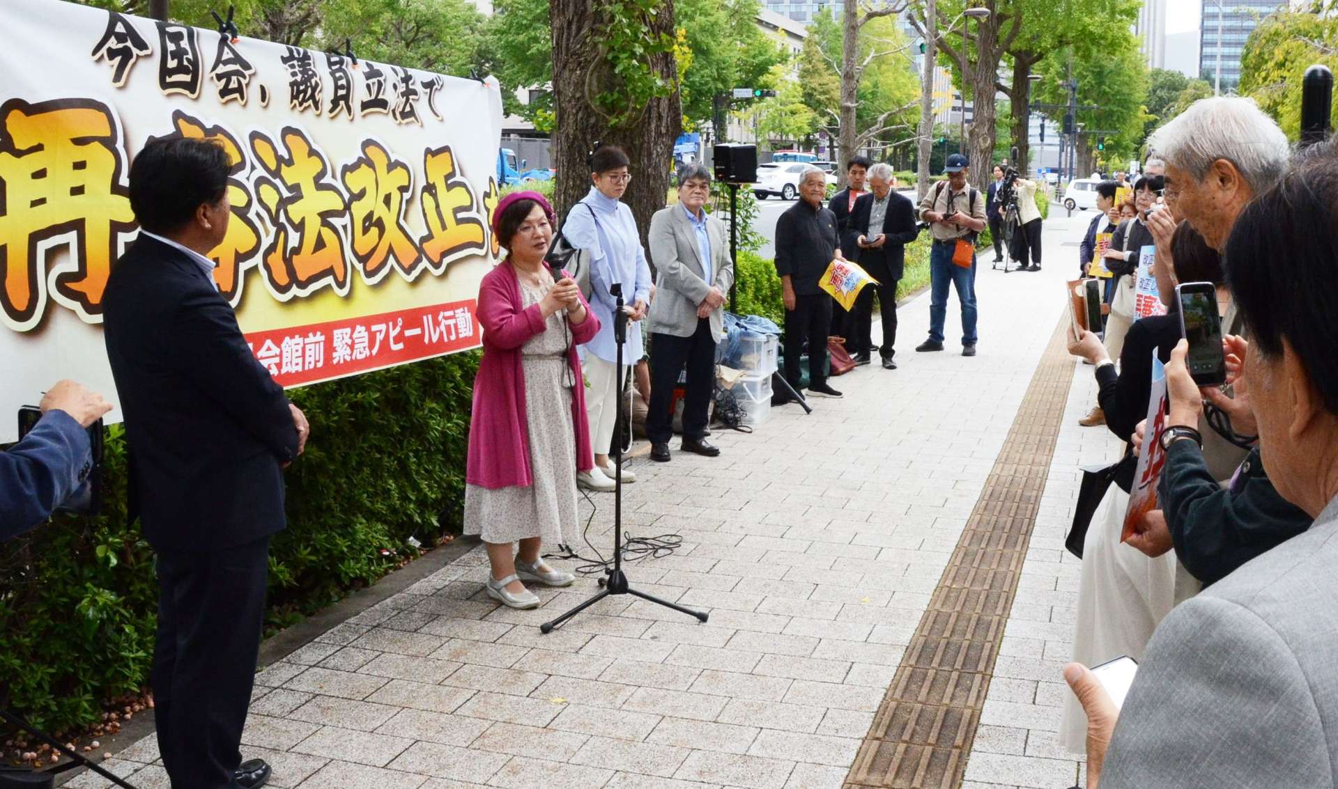 市民団体の街頭行動であいさつする鴨志田祐美弁護士＝１５日、東京都千代田区