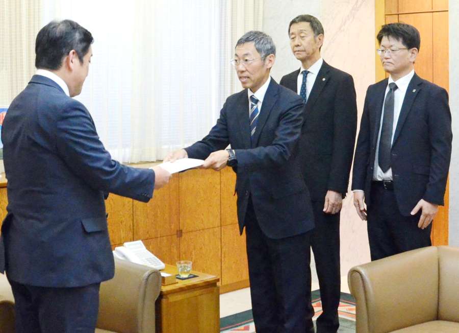 塩田康一知事（左）に要望書を手渡す肥薩線利用促進・魅力発信協議会＝２９日、県庁