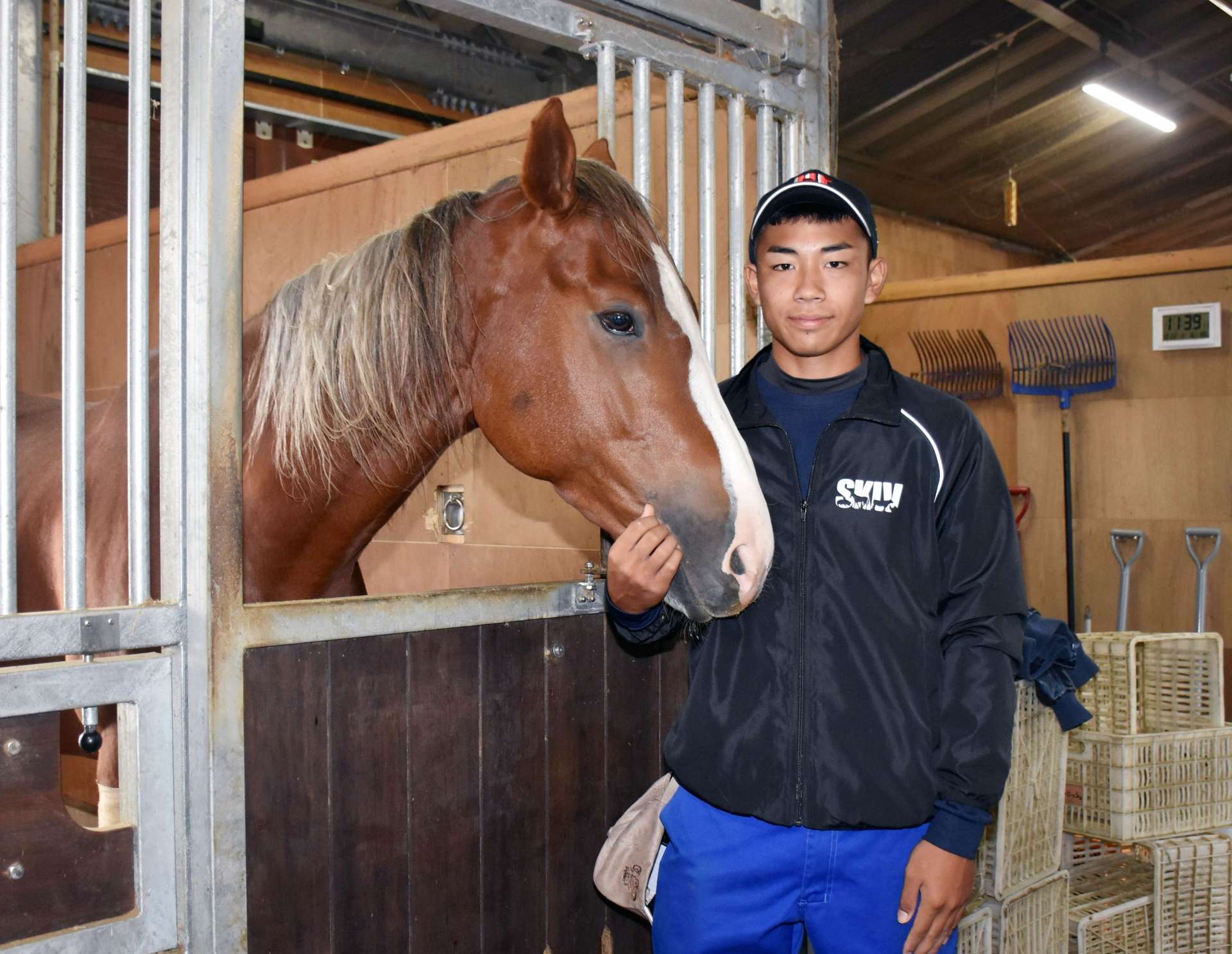 馬に寄り添う持田剛紀さん＝曽於市財部の南九州畜産獣医学拠点