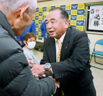 無投票当選が決まり支持者と握手する本坊輝雄氏＝９日、南さつま市加世田麓町